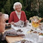 A group of people sitting around a table having a meal and exchanging wellness tips.