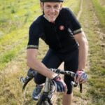 A man riding a bike in a field, showcasing his fitness and embracing the outdoors for healthy aging.