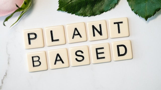 A visually appealing arrangement of the word "plant-based" carefully spelled out on a sleek marble table, highlighting the essence of healthy aging and anti-aging tips.