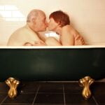 A man and woman enjoying a romantic moment in a bathtub.