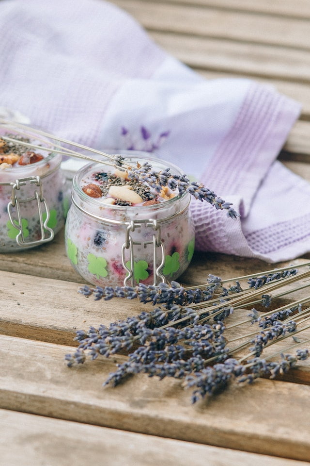 Two jars with lavender and nuts on a wooden table, offering wellness tips.