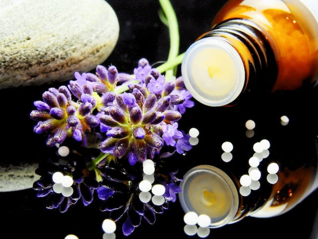 A bottle of lavender essential oil with a stone for wellness tips.