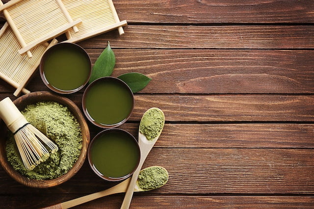 Matcha powder in bowls on a wooden table, perfect for diet advice and wellness tips.