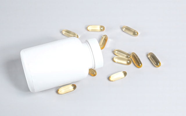 A bottle of vitamin capsules, offering longevity tips on a white background.