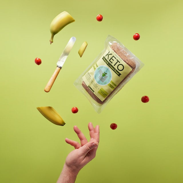 A hand with a knife and bananas flies over a bag of bread, providing wellness tips.