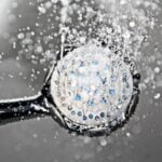 A shower head with water coming out of it, providing a refreshing bathing experience.