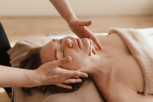 A woman receiving a rejuvenating massage at a spa, while also being provided with wellness tips.