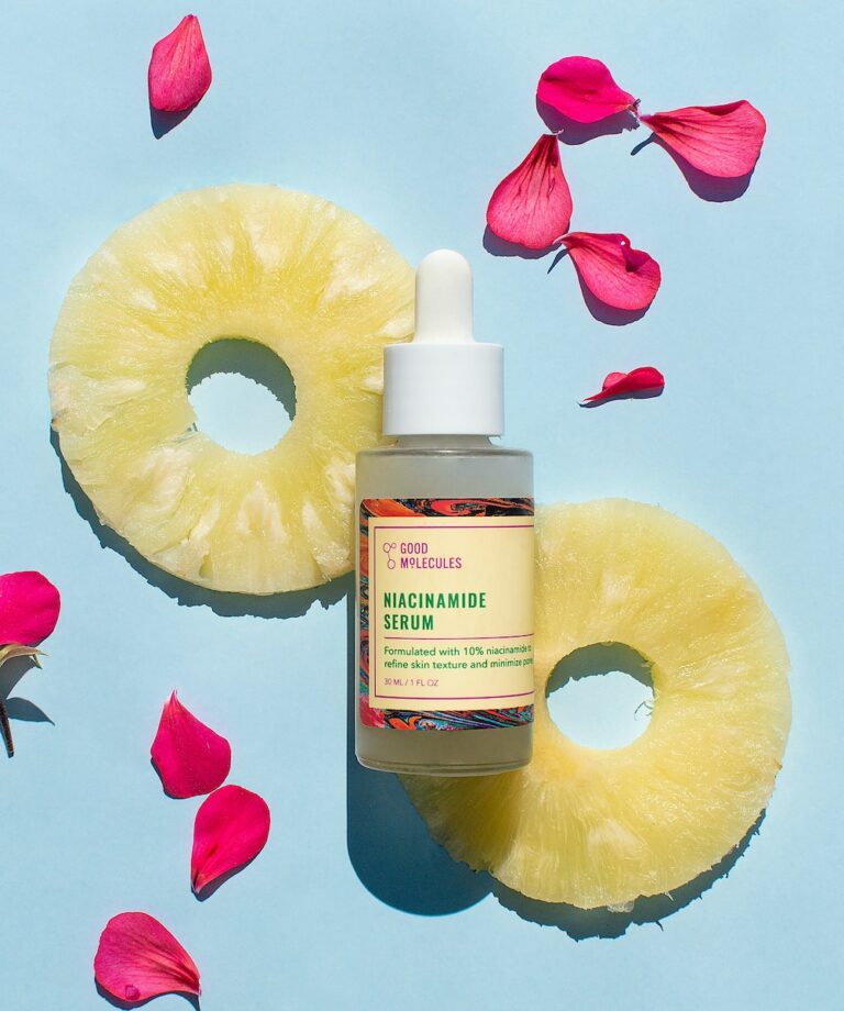 A bottle of pineapple oil surrounded by rose petals, providing rejuvenating anti-aging benefits.