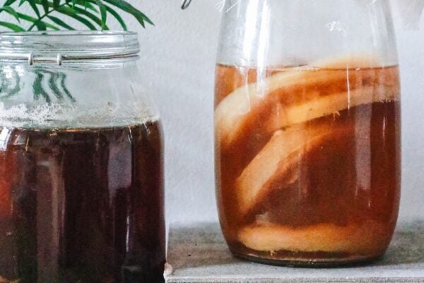 Jars with kombucha and dark herbal beverage