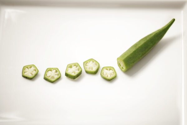 A plate of green peppers, known for their wellness and longevity benefits, showcased on a clean white plate.