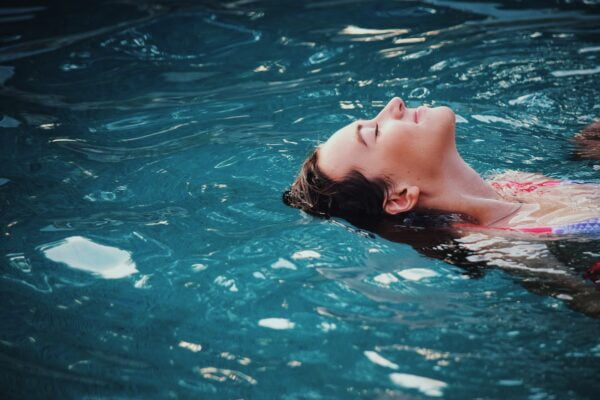A woman in a bikini floating in a pool, embodying wellness and anti-aging tips.