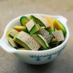 Fresh cantaloupe slices in a bowl on a table.