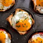 A muffin tin filled with eggs and herbs - a delicious and healthy option for senior health and wellness.