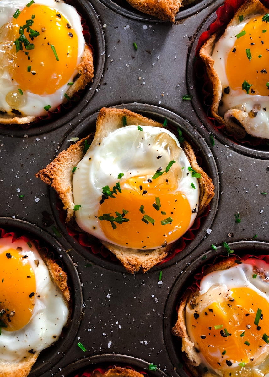 A muffin tin filled with eggs and herbs - a delicious and healthy option for senior health and wellness.