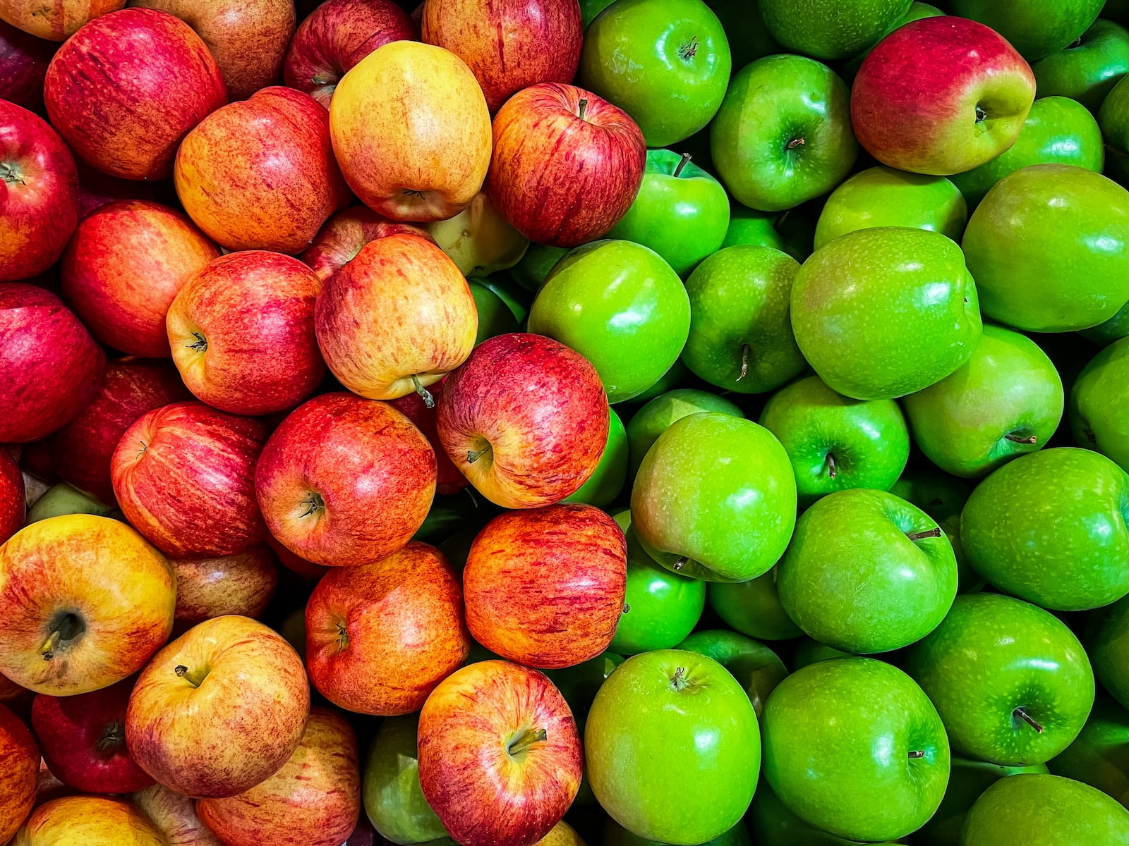 A colorful assortment of apples, including vibrant red and green varieties, with the addition of sunny yellow ones.