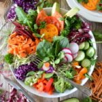 A colorful salad with carrots, cucumbers, tomatoes and avocados that promotes longevity and senior health.