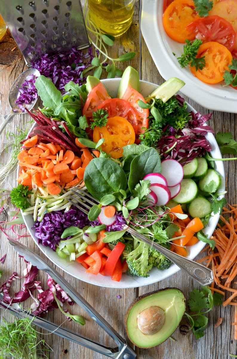A colorful salad with carrots, cucumbers, tomatoes and avocados that promotes longevity and senior health.