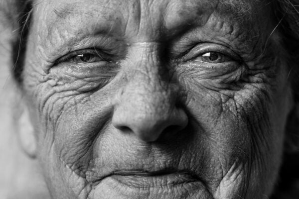 An old woman captured in a black and white photo.