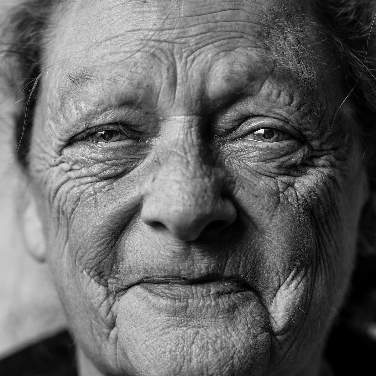 An old woman captured in a black and white photo.